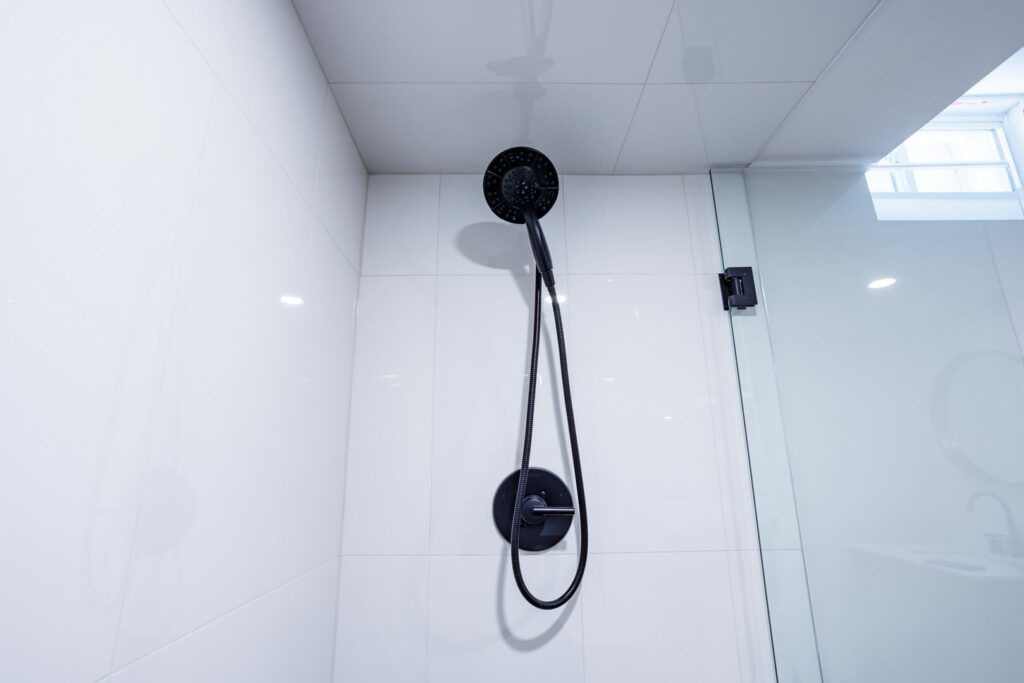 black shower heads with white wall tiles