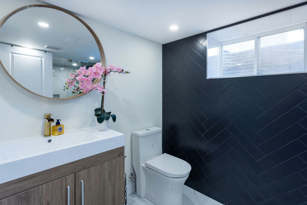 parallel tiled bathroom wall with black zig zag glossy tiles and toilet seat