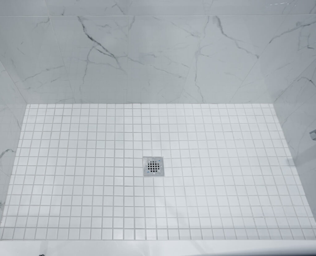 white mosaic shower unit flooring with water drain