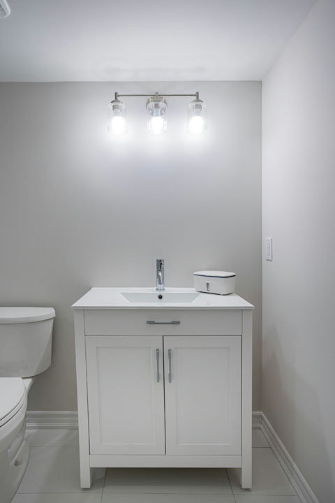 white vanity with classic light lamps and white countertop