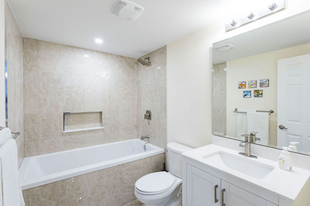 modern bathroom renovation with vanity, bathtub, and toilet seat