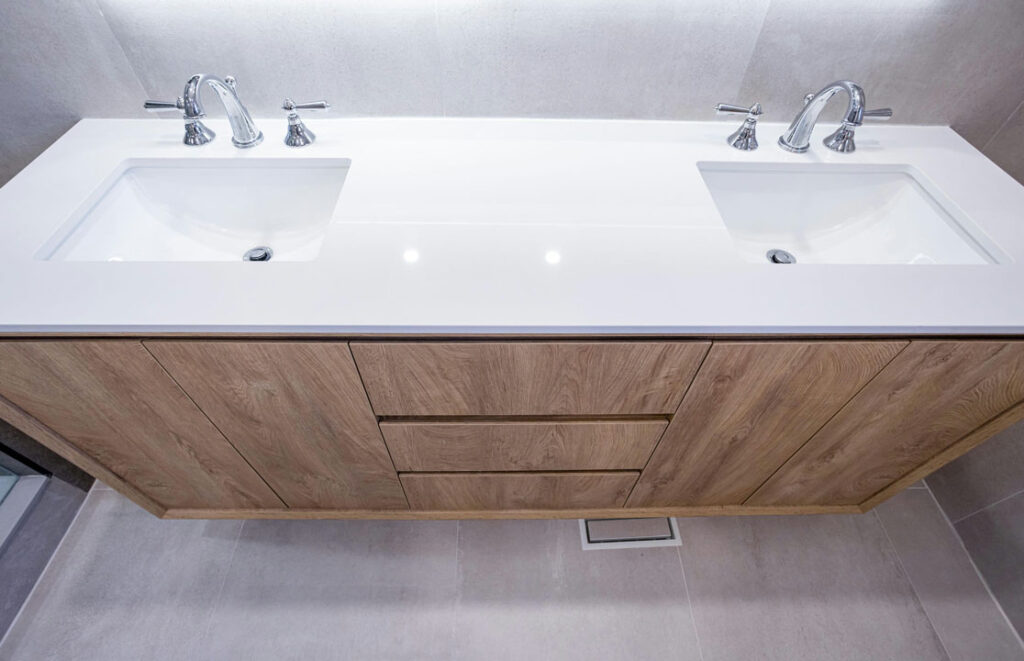 glossy white ceramic countertop with dual basin with faucets