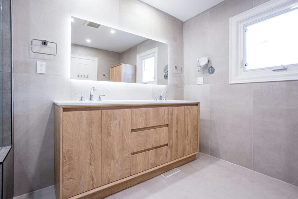 large wooden vanity with large bathroom mirror and marble flooring