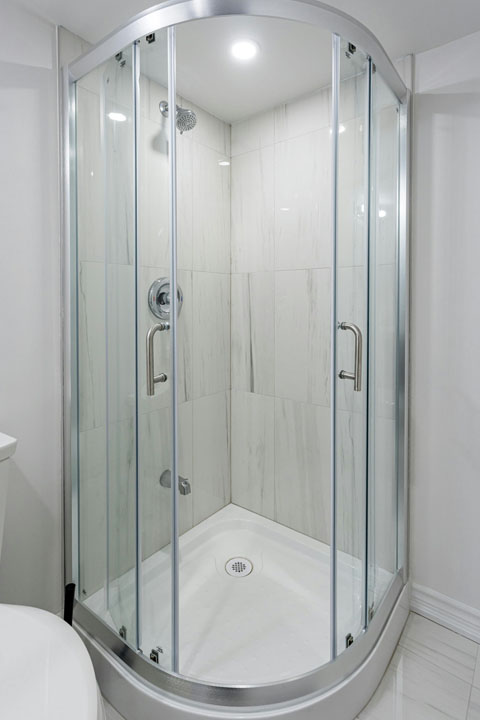 sliding glass door of shower unit with tiled wall