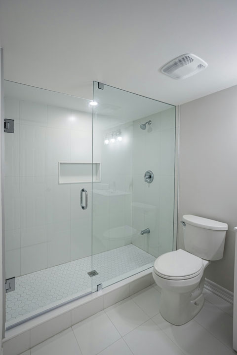 shower space glass door with tiled wall and hexagon mosaic flooring