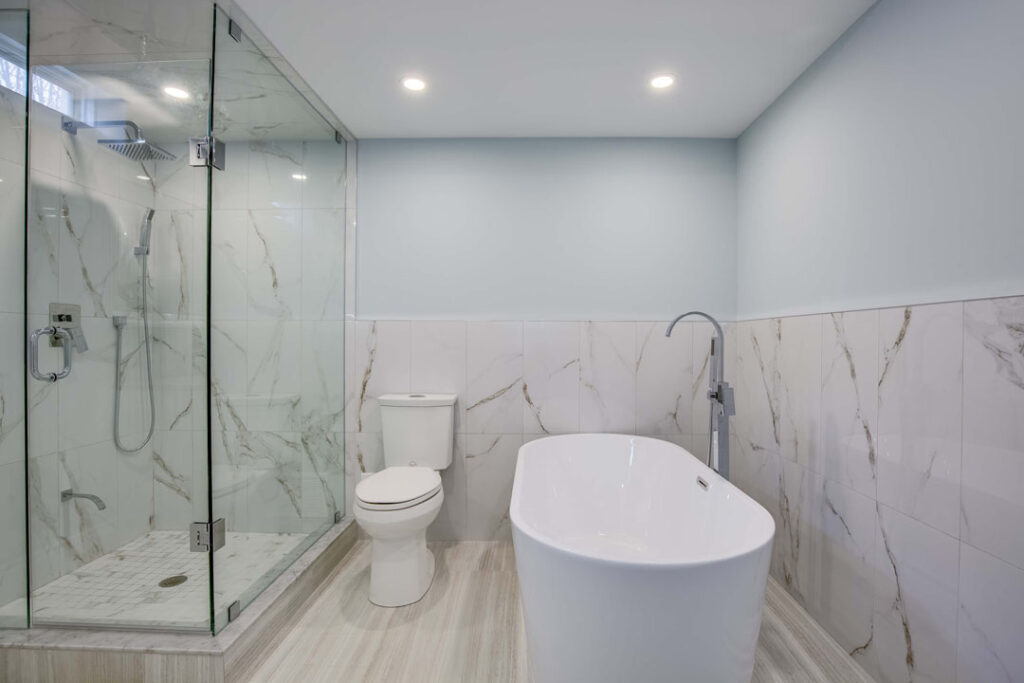 luxury bathroom renovation with white bathtub and flooring with corner shower unit