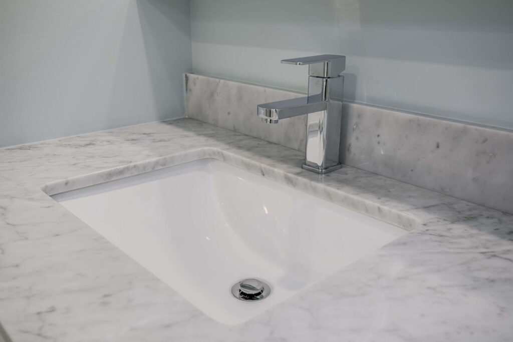 bathroom basin sink with marble countertop and water tap