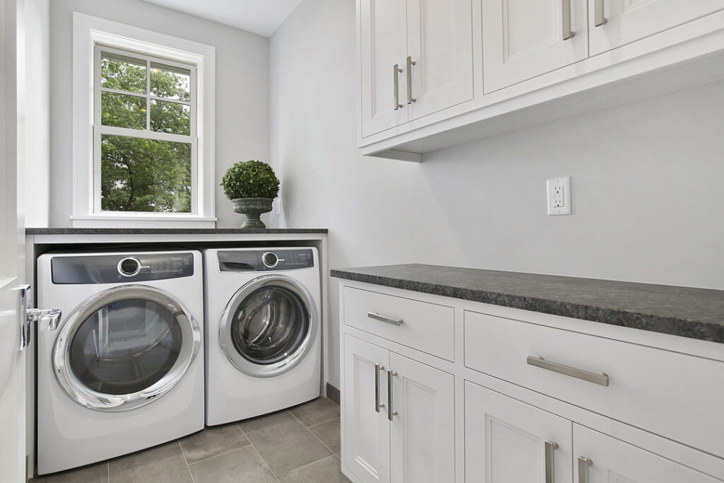 white laundry room with washer and dryer space and cabinets with countertop