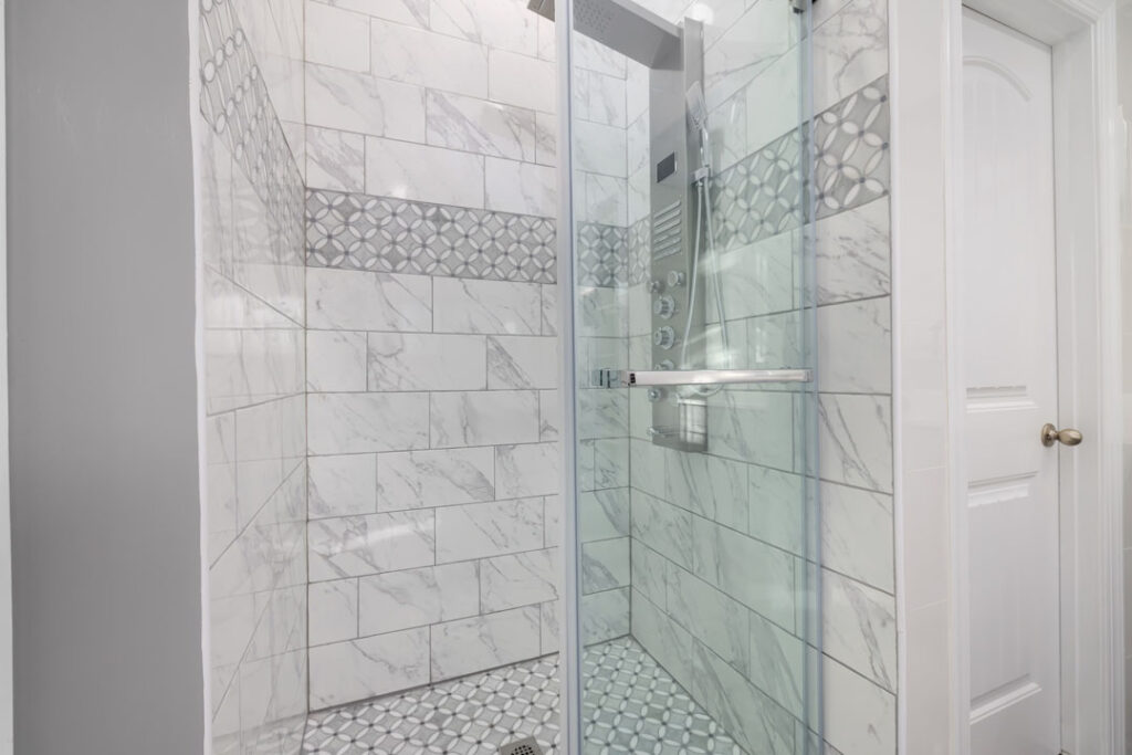 renovated shower unit with multifunctional shower heads and marble tiled shower wall